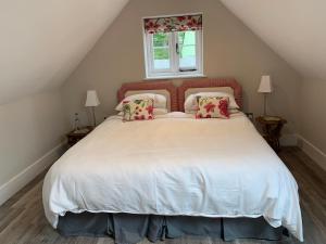 een slaapkamer met een groot wit bed met rode kussens bij The Barn in Gillingham