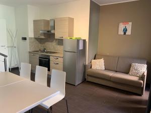 a kitchen with a couch and a table and a refrigerator at HH Hermoso Housing VALENZA in Valenza