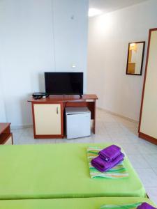 a room with a bed and a desk with a television at Kъща за гости Прохлада 3 и 4 етаж in Sinemorets