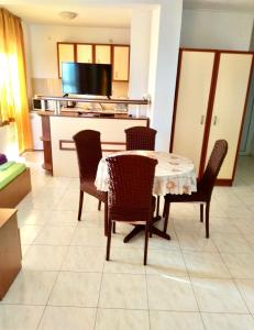 a kitchen with a table and chairs and a television at Kъща за гости Прохлада 3 и 4 етаж in Sinemorets
