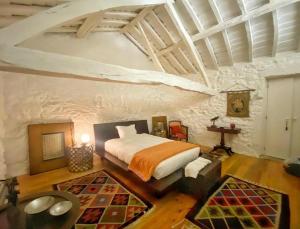 a bedroom with a bed in a stone wall at Casa do Cruzeiro in Paredes de Coura