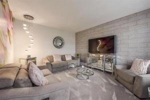 ウォーターロービルにあるLuxury 4 Bedroom Detached Houseのソファと薄型テレビのあるリビングルーム