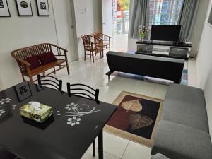 a living room with two tables and a couch at Zaara Homestay Krubong Alor Gajah Ayer Keroh Melaka in Malacca