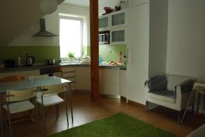 cocina con mesa, sillas y ventana en Penzion Emilia, en Ružomberok