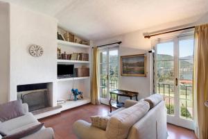 uma sala de estar com um sofá e uma lareira em Residence I Prati di Giussana em Lierna
