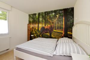 una camera da letto con un cervo nel murale della foresta di Ferienhaus am Fusse des Rennsteig/ Haus Anna a Suhl