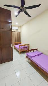 2 letti in una camera con ventilatore a soffitto di Sentosa2Stay Gong Badak Kuala Terengganu a Kampong Gong Badak
