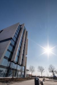 a large building with a sky background at Van der Valk Hotel A4 Schiphol in Hoofddorp