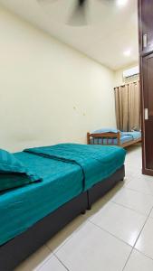 a bedroom with a bed with a blue blanket at Sentosa2Stay Gong Badak Kuala Terengganu in Kampong Gong Badak