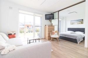 a white bedroom with a bed and a couch at Green Shine Apartment, By Cohost in Palanga +140 photos