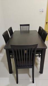 un tavolo da pranzo nero con quattro sedie intorno di Sentosa2Stay Gong Badak Kuala Terengganu a Kampong Gong Badak