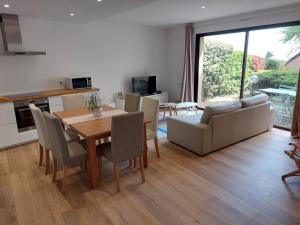 罗德兹Le DenysPuech 55m2 plein centre avec jardin!的配有桌椅的厨房和客厅