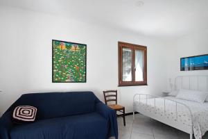 a bedroom with a bed and a couch and a window at Monolocale Fattorialmare Viola in Camogli