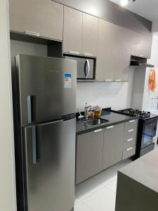 eine Küche mit einem Kühlschrank aus Edelstahl in der Unterkunft Apartamento em condominio praia clube in Caraguatatuba