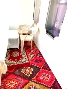 a room with a table and chairs and a rug at Pangong Delight Camps and Cottages in Spangmik