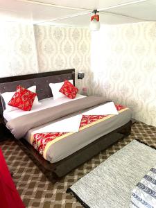 a bedroom with a bed with red pillows on it at Pangong Delight Camps and Cottages in Spangmik