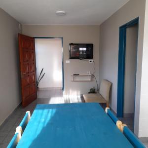 sala de estar con mesa azul y TV en EsKel I en Esquel