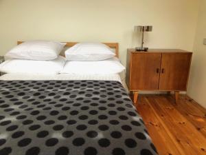 a bedroom with two beds and a wooden dresser at Holiday House Randu Pļavas in Salacgrīva