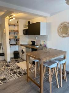 - une cuisine avec une table en bois et des chaises dans l'établissement Appt 2 pièces Port Fréjus - méga terrasse + garage, à Fréjus
