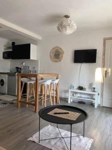 ein Wohnzimmer mit einem Tisch und einer Küche in der Unterkunft Appt 2 pièces Port Fréjus - méga terrasse + garage in Fréjus