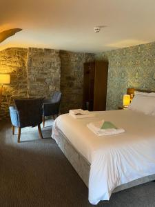 a hotel room with a large bed and a desk at rooms @ the dolau inn in New Quay