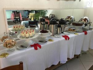 una mesa con un buffet de comida. en Aratinga Inn en Abraão