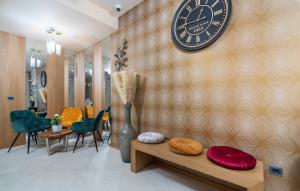 a large clock on a wall with a table and chairs at Hotel Dua Residence in Poreč