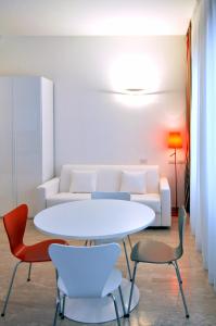 un soggiorno con tavolo e sedie bianchi di BB Hotels Aparthotel Bocconi a Milano