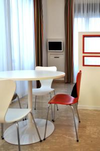 comedor con mesa y sillas en BB Hotels Aparthotel Bocconi en Milán