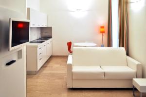 a white living room with a couch and a table at BB Hotels Aparthotel Bocconi in Milan