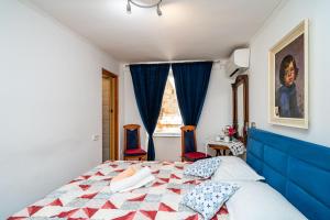 um quarto com uma cama com uma cabeceira azul e uma janela em Rooms Fausta Old Town em Dubrovnik