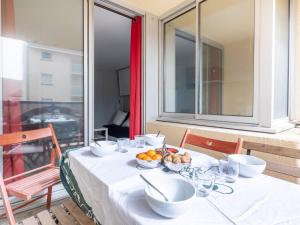 Una mesa con un bol de fruta en un balcón. en Apartment Les Hélianthes-1 by Interhome, en Lacanau-Océan