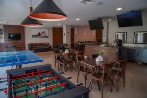a dining room with a ping pong table in a restaurant at Transamerica Fit Vitória Reta da Penha in Vitória