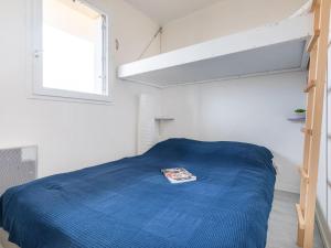 Un dormitorio con una cama con un edredón azul. en Apartment Les Hélianthes-1 by Interhome, en Lacanau-Océan