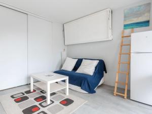 Un pequeño dormitorio con una cama y una mesa. en Apartment Les Hélianthes-1 by Interhome, en Lacanau-Océan