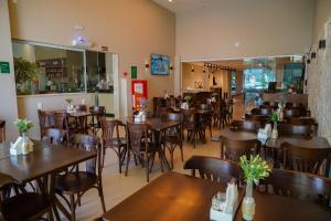 a dining room with tables and chairs in a restaurant at Transamerica Fit Vitória Reta da Penha in Vitória