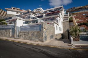 um edifício branco ao lado de uma rua em Luxurious apartment with large terrace and sea views em Tabaiba