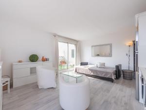 a white living room with a bed and a table at Apartment Turquoise-8 by Interhome in Cavalaire-sur-Mer +16 photos