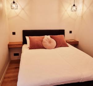 um quarto com uma cama branca e 2 almofadas em Supeluse 7-1 Guest Apartment by Annalie Apartments em Pärnu