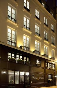 a large building with a lit up facade at night at Hôtel Caron le Marais in Paris