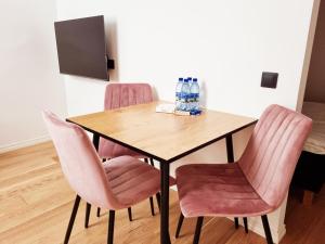 a dining room table and chairs with pink chairs at Supeluse 7-1 Guest Apartment by Annalie Apartments in Pärnu