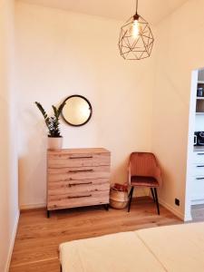 a bedroom with a dresser and a mirror and a chair at Supeluse 7-1 Guest Apartment by Annalie Apartments in Pärnu