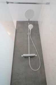 y baño con ducha con cabezal de ducha. en Luxurious apartment with large terrace and sea views en Tabaiba
