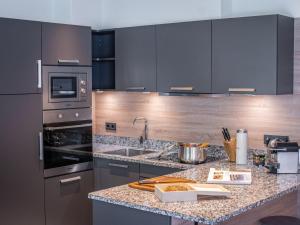a kitchen with stainless steel appliances and a granite counter top at Apartment Top1 by Interhome in Zell am See