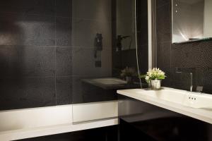 a bathroom with a sink and a mirror and a tub at Hôtel Caron le Marais in Paris
