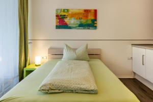 a bedroom with a green bed with a painting on the wall at Apartment 3 in Rielasingen-Worblingen