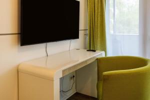a desk with a television on a wall with a chair at Apartment 3 in Rielasingen-Worblingen