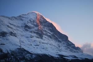 a mountain covered in snow with the sun shining on it at Chalet Spillstatt in Grindelwald