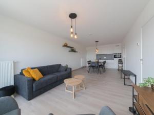 uma sala de estar com um sofá e uma mesa em Apartment Railway to the Beach by Interhome em Blankenberge