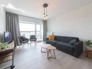 a living room with a couch and a table at Apartment Railway to the Beach with balcony by Interhome in Blankenberge +15 photos